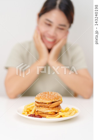 happy woman eating Juicy beef burger with melted cheddar cheese, potato chips. Unhealthy, High calorie, Fast food craving, Obesity, diet, weight loss, junk food and lifestyle happy woman eating Juicy beef burger with melted cheddar cheese, potato chips. Unhealthy, High calorie, Fast food craving, Obesity, diet, weight loss, junk food and lifestyle 143240198