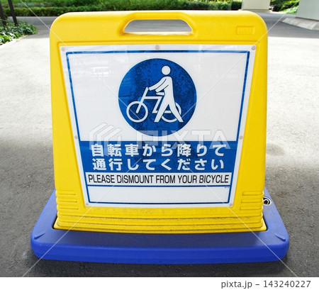 「自転車から降りて通行してください」と書かれた黄色と青のサインスタンド 「自転車から降りて通行してください」と書かれた黄色と青のサインスタンド 143240227