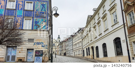 Cobblestone street in Warsaw Old Town with colorful mosaic mural on a building facade - Warsaw, Poland - January 26, 2023 143240756