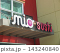 Mio Sushi restaurant exterior neon sign on a modern red and beige building facade in Ruston.- June 13, 2026 Ruston WA, USA 143240840