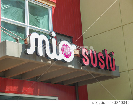 Mio Sushi restaurant exterior neon sign on a modern red and beige building facade in Ruston.- June 13, 2026 Ruston WA, USA 143240840
