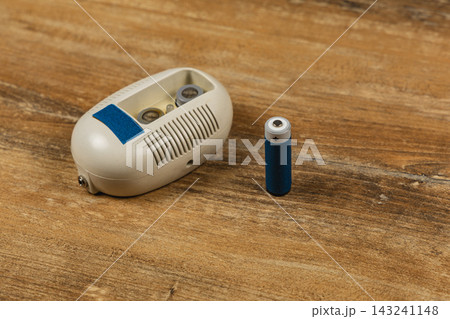 Smoke detector and battery on a wooden surface for home safety 143241148
