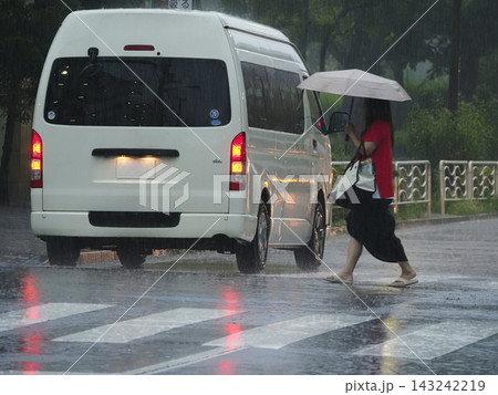 雨の日に横断歩道を渡る歩行者 雨の日に横断歩道を渡る歩行者 143242219