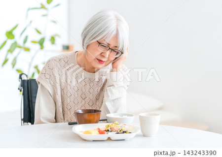 食欲不振,食欲低下で食べられず困る,悩む車椅子に乗るシニア女性 143243390