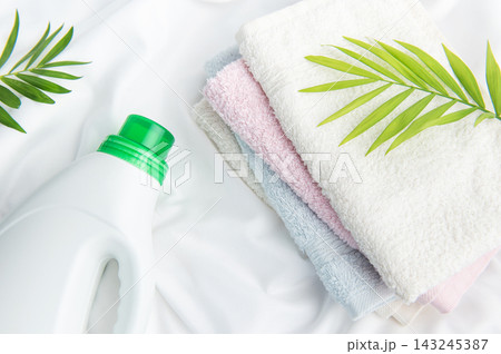 Laundry detergent bottle with fresh towels and green leaf 143245387