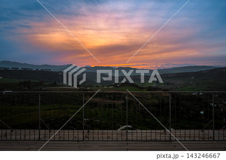 Vivid sunset over Ronda countryside seen from a viewpoint railing Vivid sunset over Ronda countryside seen from a viewpoint railing 143246667