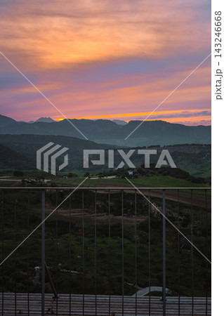Vivid sunset over Ronda countryside seen from a viewpoint railing Vivid sunset over Ronda countryside seen from a viewpoint railing 143246668
