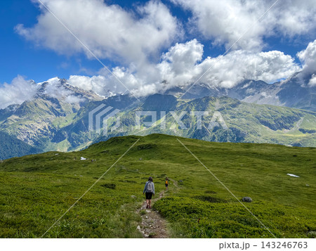 Hikers walking along alpine trail facing Mont Blanc, France 143246763