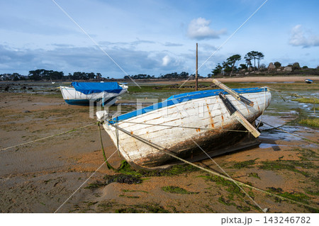 Old weathered boat beached on tidal flats in Tregastel, France 143246782