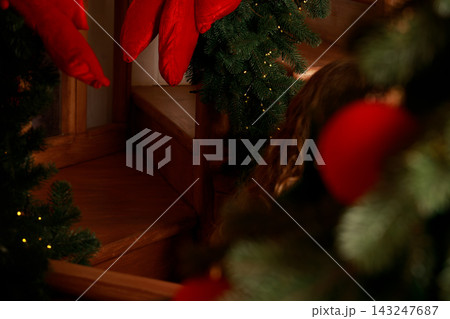 Cozy Christmas interior pine garland and warm lamp illumination at evening dusk time atmosphere 143247687