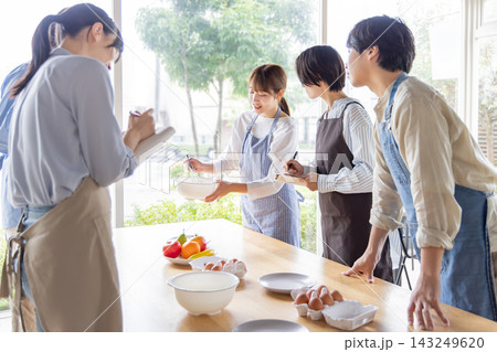 料理教室で一緒に調理を楽しむ日本人の男女グループ 143249620