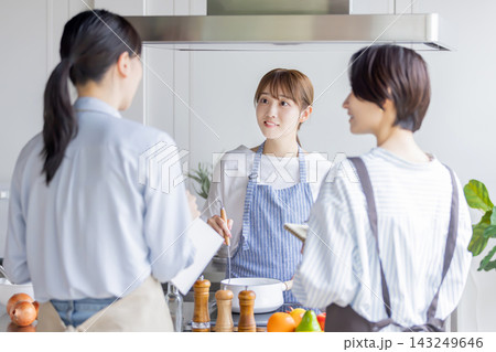 料理教室で調理を実演しながら説明する日本人女性 143249646