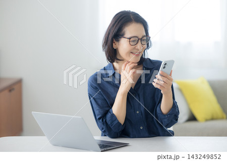 スマホを見るミドル女性　  143249852