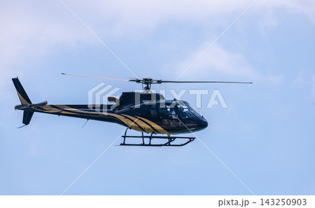 Helicopter flying through a clear blue sky with its rotor blades in motion with copy space Helicopter flying through a clear blue sky with its rotor blades in motion with copy space 143250903