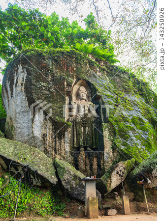 Ancient rock-carved Kustarajagala statue sculpted into a massive granite boulder at Weligama. 143250926