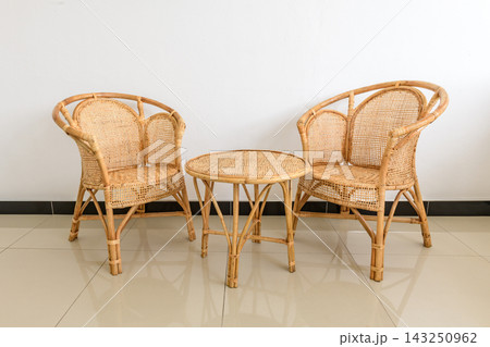 Rattan chairs and a round coffee table in a modern living room Rattan chairs and a round coffee table in a modern living room 143250962