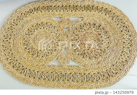 Woven rattan floor mat with circular spiral pattern 143250979