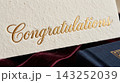 Extreme close up detail focusing on the luxurious texture of a gift card resting on a book cover 143252039