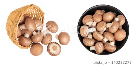 Brown champignon mushroom a wicker basket and ceramic bowl isolated on white background. Top view. Flat lay Brown champignon mushroom a wicker basket and ceramic bowl isolated on white background. Top view. Flat lay 143252275