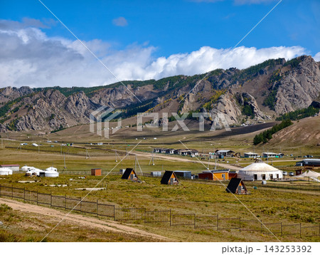 Panoramic landscape view of traditional Mongolian yurts or gers clustered in a tourist camp surrounded by rolling green hills in Gorkhi-Terelj National Park, Mongolia 143253392