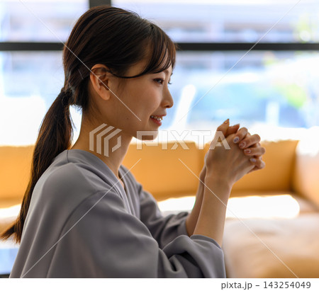 横顔の女性、手を合わせて微笑む 横顔の女性、手を合わせて微笑む 143254049
