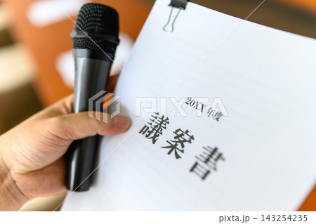 議案書を持つ手とマイク、会議や質疑応答 議案書を持つ手とマイク、会議や質疑応答 143254235