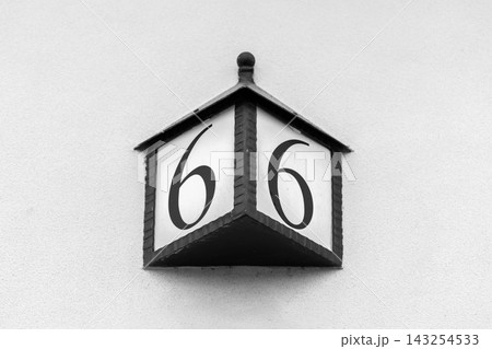 Vintage black-and-white house number 6 sign mounted on a white wall Vintage black-and-white house number 6 sign mounted on a white wall 143254533