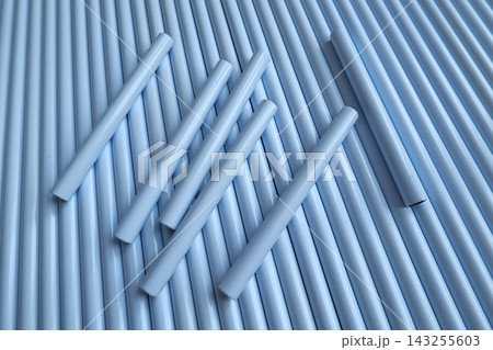 Hand holding white plastic pipes against a background of more pipes Hand holding white plastic pipes against a background of more pipes 143255603