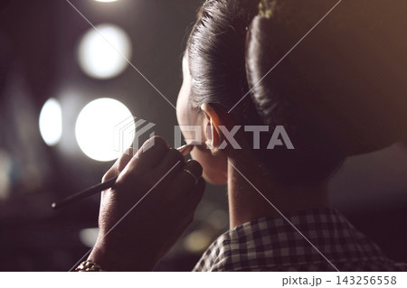 Makeup Artist Applying Finishing Touches To Model Backstage In Dressing Room With Vanity Lights 143256558