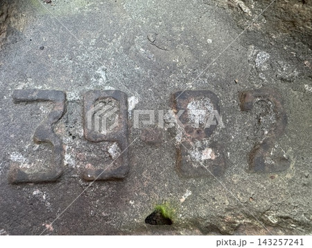 Weathered stone surface featuring the carved numbers thirty nine and eighty two 143257241