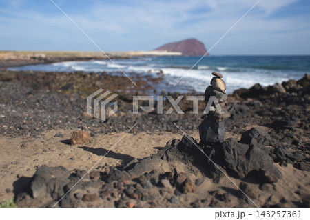 Stone cairn on a volcanic beach in Tenerife, Spain 143257361