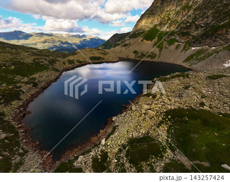 Mountain Lake in Rocky Valley with Clouds 143257424
