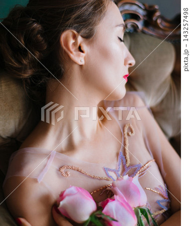 Extreme close-up of a woman's profile with roses and gold embroidery 143257498