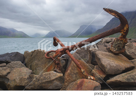 Large rusty anchor on a rocky pier in Flateyri, Iceland 143257583