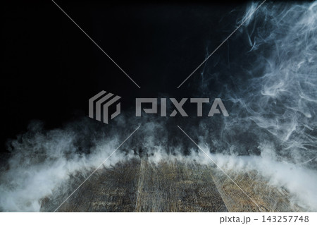 Smoke rising from wooden floor on black background Smoke rising from wooden floor on black background 143257748