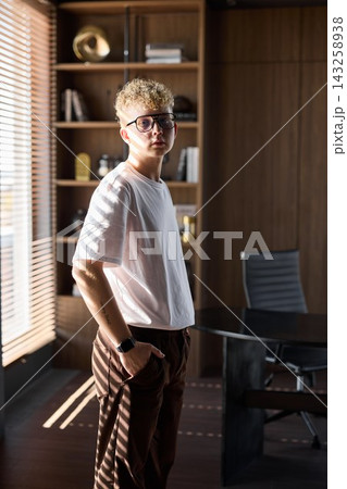 Male figure with thoughtful expression beside decorative shelves Male figure with thoughtful expression beside decorative shelves 143258938
