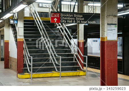 Exit stairs inside Brooklyn Bridge City Hall subway station in Lower Manhattan, New York City. Steel railings and overhead transit signage frame the underground platform environment. Exit stairs inside Brooklyn Bridge City Hall subway station in Lower Manhattan, New York City. Steel railings and overhead transit signage frame the underground platform environment. 143259023