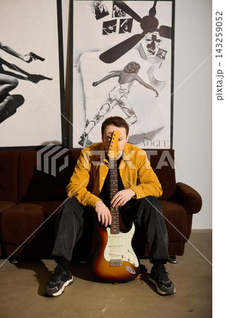 Caucasian musician playful introspective pose with guitar 143259052