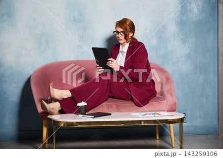 Fashion professional analyzes styling options within sleek studio setting 143259106