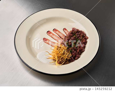 Diced tuna tartare on white porcelain plate with crispy fried strings and green herb garnish for gourmet appetizer Diced tuna tartare on white porcelain plate with crispy fried strings and green herb garnish for gourmet appetizer 143259212