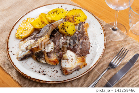On white plate-grilled beef ribs garnished with fried potatoes 143259466