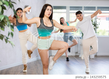 Expressive teen girl krumper dancing with group of teenagers in studio Expressive teen girl krumper dancing with group of teenagers in studio 143259575