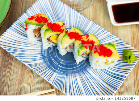 Uramaki - Dragon sushi roll with salmon and mango, tropical flavor. Uramaki - Dragon sushi roll with salmon and mango, tropical flavor. 143259697