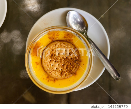 Delicate custard dessert made from milk, eggs and sugar, ornamented with soda biscuit. Delicate custard dessert made from milk, eggs and sugar, ornamented with soda biscuit. 143259779