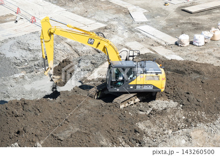 大型建設現場で油圧ショベルが土砂を掘削する作業 大型建設現場で油圧ショベルが土砂を掘削する作業 143260500