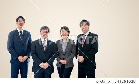 ベージュ背景で並ぶ笑顔の会社員4人、温かい雰囲気のビジネスチーム 143261029