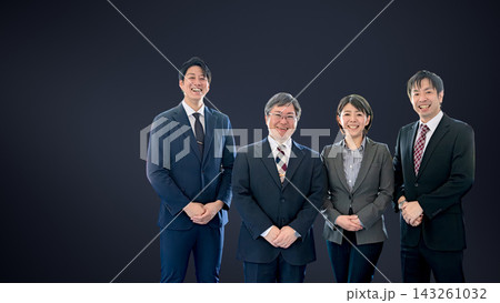 暗い背景の右側に並ぶ笑顔のビジネスパーソン4人、左側に余白 143261032