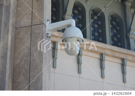 Security camera mounted on building exterior observing the surroundings Security camera mounted on building exterior observing the surroundings 143262804
