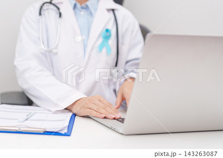 doctor using laptop and report notes on notebook. blue Ribbon concept of November Prostate Cancer Awareness month, Diabetes day , Men Health, International men, Father day. world cancer day doctor using laptop and report notes on notebook. blue Ribbon concept of November Prostate Cancer Awareness month, Diabetes day , Men Health, International men, Father day. world cancer day 143263087