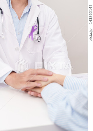 doctor holding patient hand to comfort and support with empathy. purple ribbon for concept of Violence, Pancreatic, Esophageal, Testicular cancer, Alzheimer, Epilepsy, Lupus and Fibromyalgia 143263145